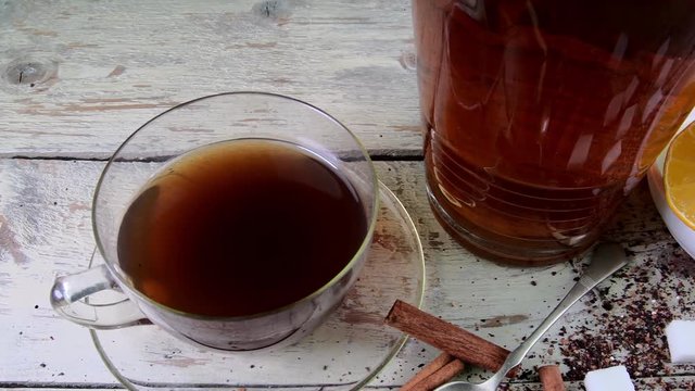 Black tea, manual squeezer with lemons. A jug of black tea and cubes of sugar.