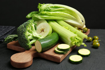 Wooden board with green vegetables and fruits on table. Food photography