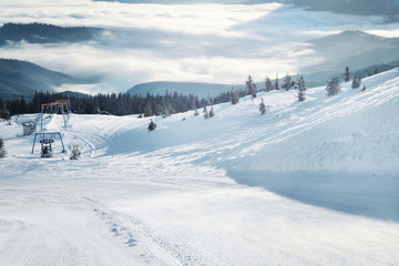 Fototapeta premium Snowy landscape with ski lift at mountain resort. Winter vacation