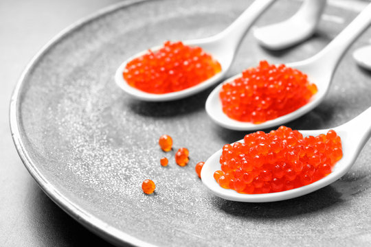 Spoons with delicious red caviar on plate
