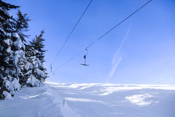 Fototapeta na wymiar Ski lift at snowy resort. Winter vacation