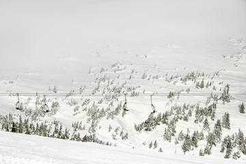 Fototapeta na wymiar Ski lift at snowy resort in mountains on winter day