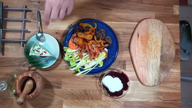 Top view prepare serving plate with shrimps, andive, beet salad and moldy cheese.