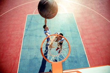 Schilderijen op glas High angle view of basketball player dunking basketball in hoop © FS-Stock