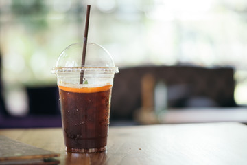 Ice coffee with lemon on wood table in cafe