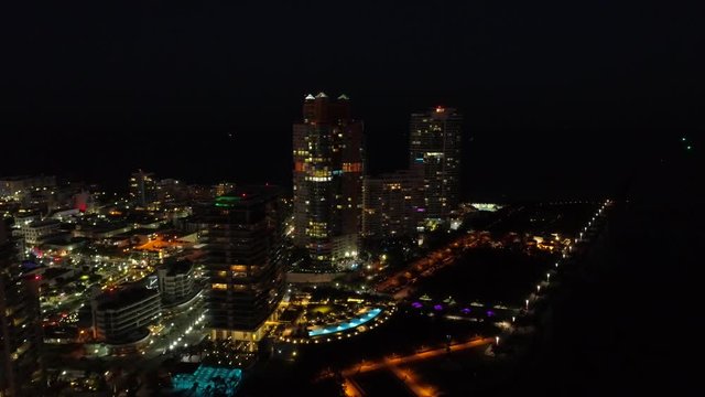 Night aerial drone footage Miami Beach condominiums illuminated South Pointe Park