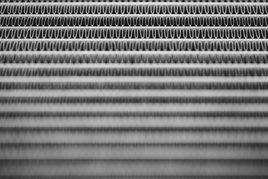 Monochrome background image of automotive radiator close up. Silver background from many duplicate lines.