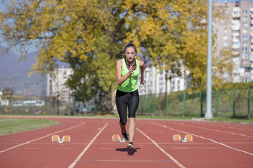 Obraz premium Female Sprinter Getting Ready to Start The Race