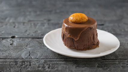 Cake on a white plate on a dark wooden table.