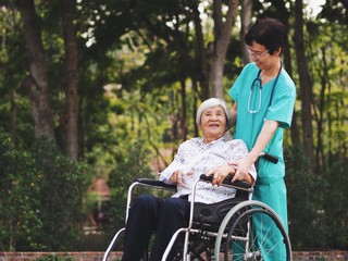 Senior  nurse take care older woman for walking in the park.