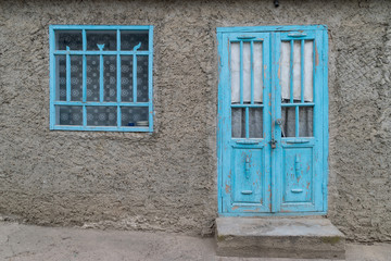 A traditional clay based house with blue window and door in Tocuz, Moldova