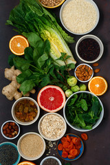 Flat lay set clean eating. Vegetarian healthy food - different vegetables and fruits, superfood, seeds, cereal, leaf vegetable on dark background top view