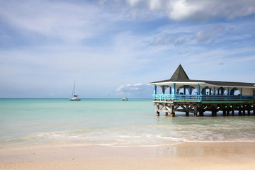 Beautiful day with a view out to sea & the pier of Runaway Beach, Antigua, Caribbean.