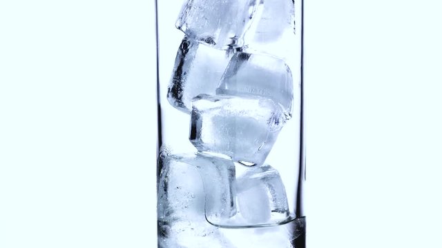 Close-up timelapse of melting ice cubes in a small glass