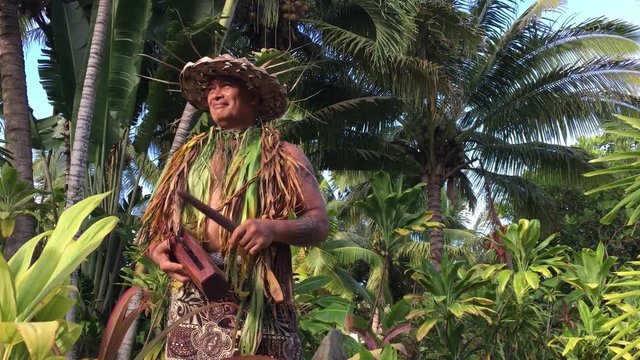 Cook Islander man plays on small wooden drum Pate in Rarotonga Cook Islands