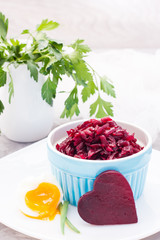 Boiled grated beet  in a bowl, chiken egg and parsley