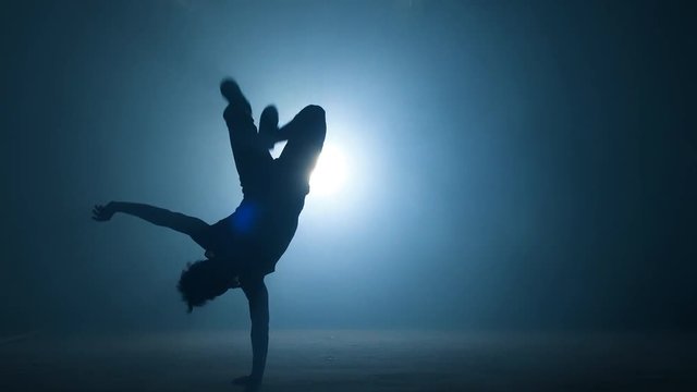 Nacked strong man is trying freeze on one hand. experienced athlet.