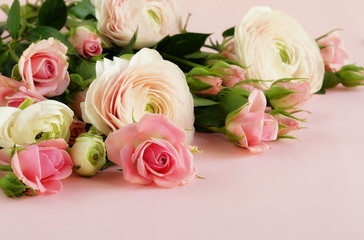 beautiful bouquet of gently pink roses and ranunculus on a pale pink background. close up. top view.copy space
