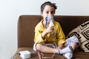 Little girl making inhalation with nebulizer at home child asthma inhaler inhalation nebulizer