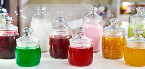 Fototapeta na wymiar Multicolored jars with jam on shelf
