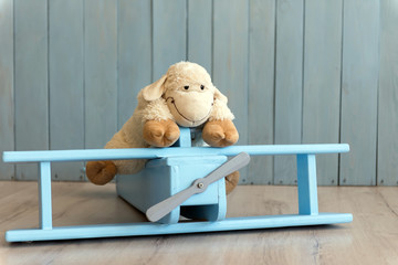 Wooden retro airplane model and sheep toy over retro vintage brown background