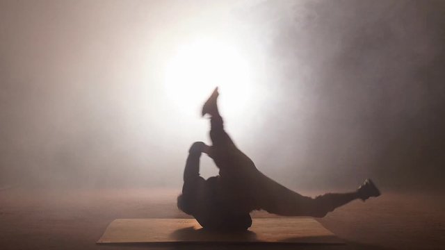Asian sportsmen is falling down on the ground while doing stunt.
