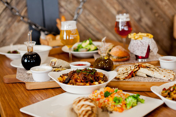 covered table with salad with soup with wine and beer with burger