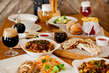 covered table with salad with soup with wine and beer with burger