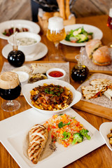 covered table with salad with soup with wine and beer with burger