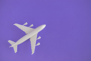 Plastic toy airplane on a violet Background and copy space