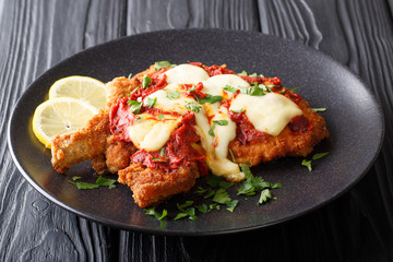 Delicious veal cutlet with mozzarella cheese, lemon and tomato sauce (milanesa napolitana)...