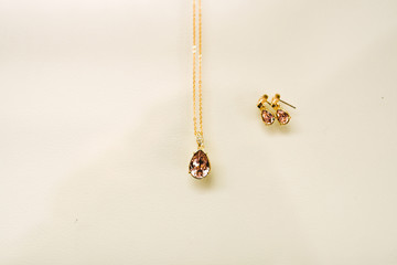 Fototapeta premium Women's wedding jewelry (earrings, pendant) on a light background, selective focus