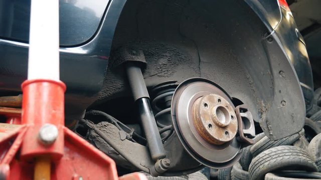 Replacement of a wheel on a black car.