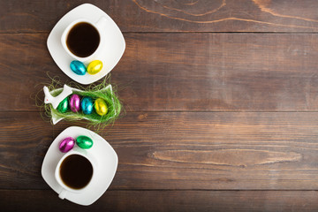 Easter concept with two cups of coffee and eggs dessert with hare, Copy space