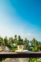 White coffee cup with beautiful paradise island sea and beach