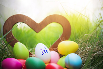 Colorful Easter eggs in a basket on green grass field 