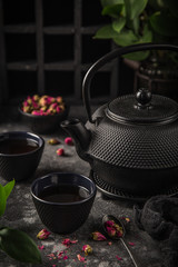 Obraz na płótnie Canvas tea set. Cast iron eastern tea pot, cups and dry rose