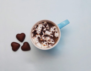 Hot Coccoa or Chocolate with a Marshmallows and Chocolates Heart Shape on Blue Background. Toned. Hot Drinks Concept. Soft Light.