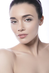 Fototapeta premium Close up of a beautiful brunette caucasian woman with fresh clean natural skin and soft smile on her face. Neutral, daily make up