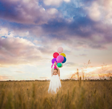girl holds balloons