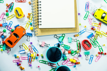 Top view of laptop, blank notebook, paper clips  and smart phone with white background and copy space.