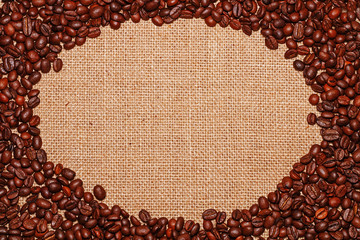 Frame on the background of sackcloth fabric lined with coffee beans in the form of an oval