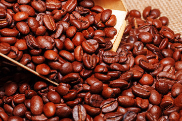 A wooden scoop puts coffee in a bag