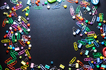 Top view of office table or desk with colorful equipment on black background with copy space for text.