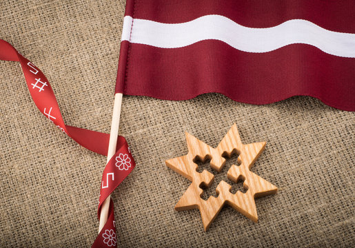 Composition of latvian flag, national ribbon and wooden sign