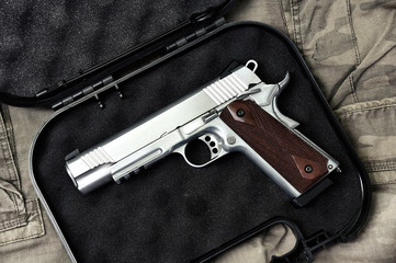 Pistol 11mm, Gun weapon series, Police handgun close-up on camouflage background.