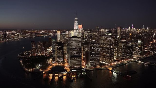 New York City aerial view of Lower Manhattan's Financial District at night from East River and the Battery Maritime Building, with Midtown Manhattan in the background