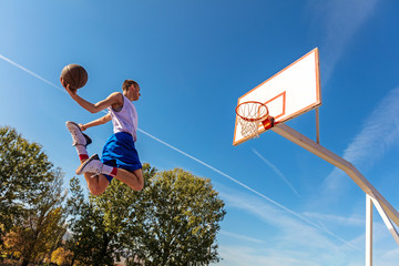 Young Basketball street player making slam dunk © FS-Stock