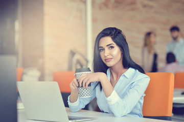 Image of woman using laptop while sitting at her desk.