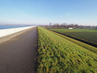 Walkway at countryside landscape of green grassy field next to artificial Goczalkowice Reservoir in...